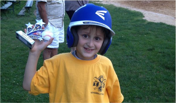 Image of Little Boy with Baseball Helmet and Carrying a Trophy